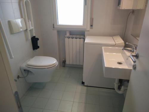 a small bathroom with a toilet and a sink at Appartamento Aquileia in Lido