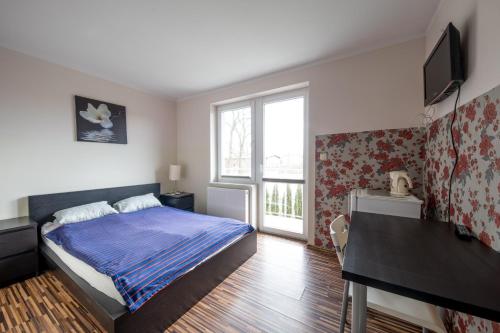 a bedroom with a bed and a desk and a window at Willa Sarbinowo in Sarbinowo