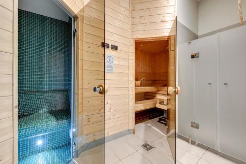 a walk in shower with a glass door in a bathroom at Apartinfo Apartments Waterlane Island SPA in Gdańsk