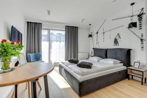 a living room with a bed and a table at Apartinfo Apartments Waterlane Island SPA in Gdańsk