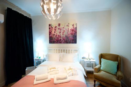 a bedroom with a large white bed with a chandelier at Old Fortress Luxury Suite in Corfu Town