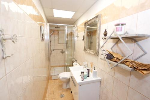 a bathroom with a toilet and a shower and a sink at Old Fortress Luxury Suite in Corfu Town