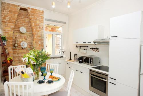 a white kitchen with a table and a microwave at Old Fortress Luxury Suite in Corfu Town
