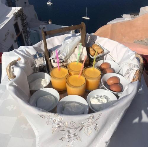 伊亚卡斯特罗伊亚别墅酒店的一个装满杯子、盘子和橙汁的篮子