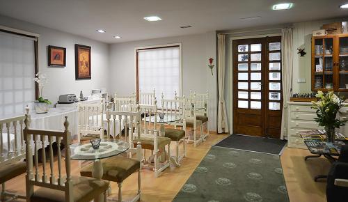 a conference room with tables and chairs and a door at Hotel Tres Carabelas in Baiona