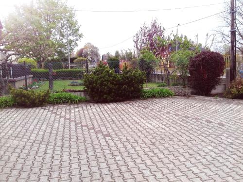 a brick driveway with a fence in a yard at St.Flórián Apartman in Keszthely