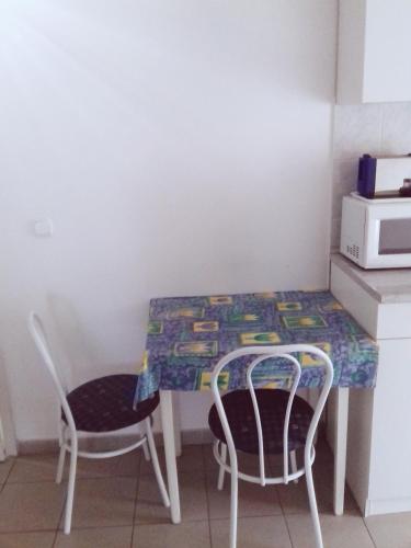 a table and two chairs in a room with a table and a table and chairs at St.Flórián Apartman in Keszthely