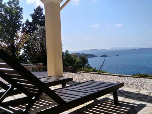 a wooden bench sitting under a gazebo overlooking the ocean at Holiday home with stunning views near Afionas in Afionas