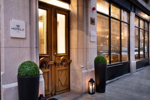 a front door of a building with two plants in front at Hotel D Geneva in Geneva