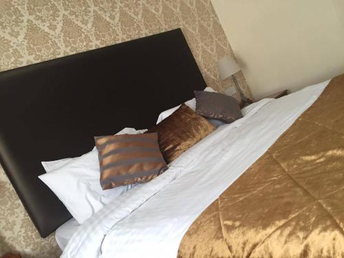 a bed with brown and white pillows on it at The Bannville Hotel in Banbridge