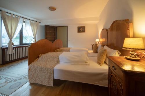 ein Schlafzimmer mit 2 Betten und einem Tisch mit einer Lampe in der Unterkunft Casa Maria in Bran