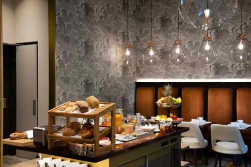 a dining room with a table with bread and pastries at Hotel D Geneva in Geneva