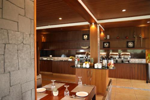a dining room with two tables and a kitchen at CONTOUR ISLAND RESORT & SPA , wayanad in Tariyod
