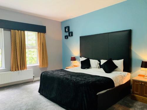 a bedroom with a large bed and two windows at The Bannville Hotel in Banbridge