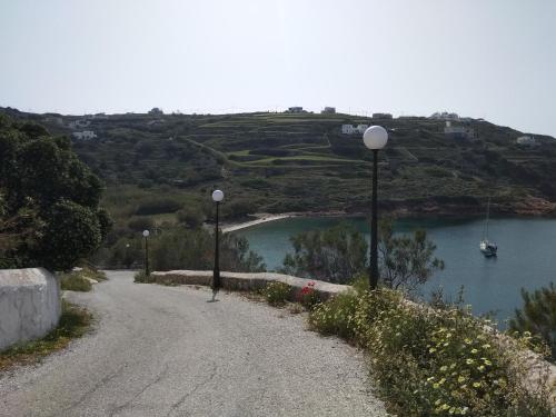 a dirt road with two street lights next to a body of water at VILA INSPIRATION - ON KINI BEACH in Kinion