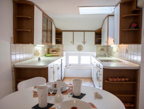 una cocina con armarios de madera y una mesa blanca en Apartment L&M, en Piran