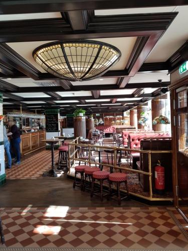 a restaurant with tables and chairs and a chandelier at Hotel Bishops Arms Mora in Mora