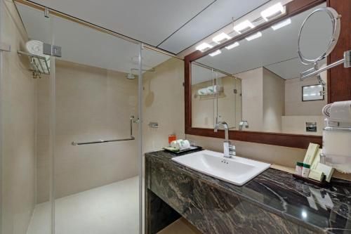 W łazience znajduje się umywalka, prysznic i lustro. w obiekcie The Fern Residency, Satara Maharashtra w mieście Satara