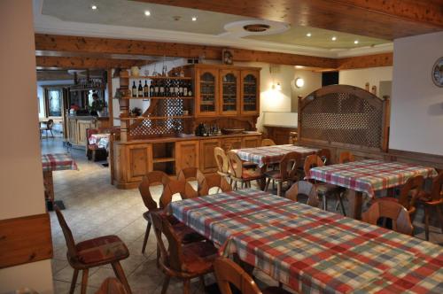 restauracja z 2 stołami i krzesłami oraz kuchnią w obiekcie Albergo Dolomiti w mieście Capriana