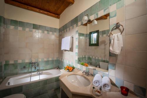 a bathroom with a sink and a bath tub at Enagron Ecotourism Village in Axós
