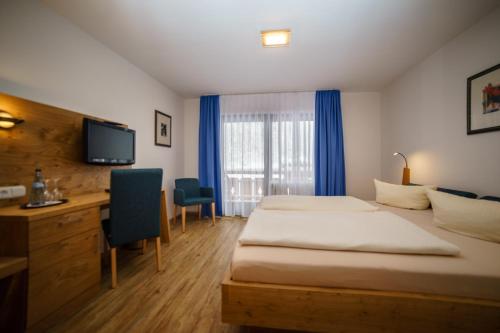 a hotel room with a bed and a television at Parkhotel Sonnenhof in Oberammergau