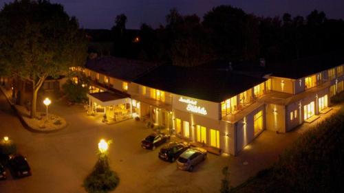 ein Gebäude mit nachts auf einem Parkplatz geparkt in der Unterkunft Landhotel Stähle in Schüttorf