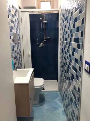 een badkamer met een toilet, een wastafel en een douche bij A due passi dal mare in Realmonte