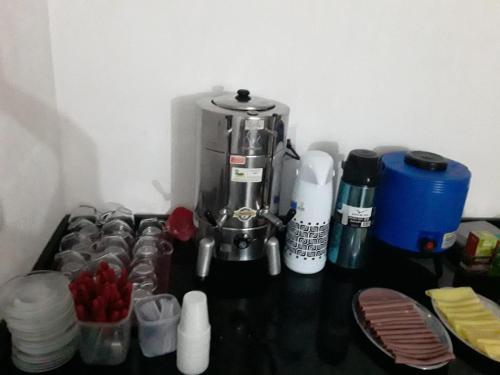 a counter top with a coffee maker and some cups at Hotel Flex In in Osasco
