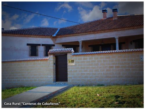 a house with a brick wall and a door at Casa Rural Las Canteras de Cabañeros in Retuerta de Bullaque