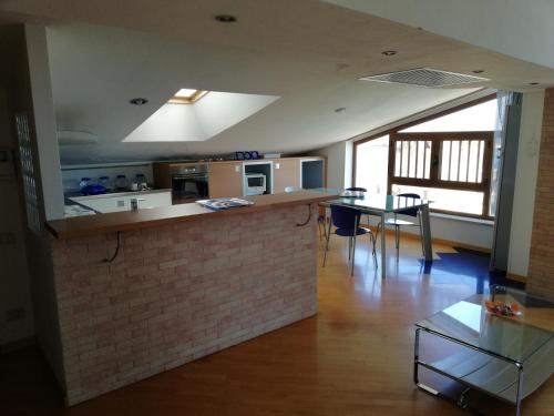 a kitchen with a counter and a table in a room at Attico "Elisa" Vista Mare in Porto Torres