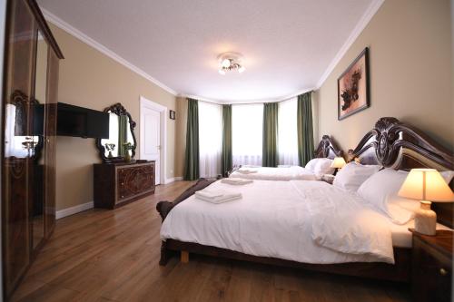 a bedroom with a large bed with white sheets at Absolut Residence Hateg in Haţeg