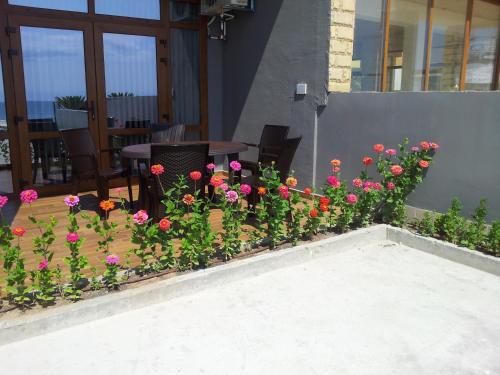 un ramo de flores en un lecho de flores junto a un patio en Hotel GAIA, en Sozopol