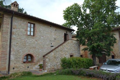 a stone house with a car parked in front of it at Agriturismo La Segolina in Colle Val D'Elsa