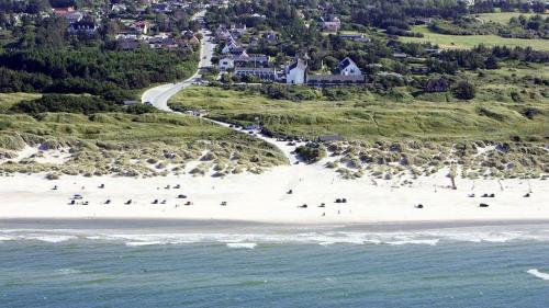 a group of people on a beach near the ocean at Tversted Strandpark in Bindslev