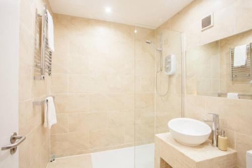 uma casa de banho com um chuveiro, um lavatório e um WC. em Stylish Merchant City Flat em Glasgow