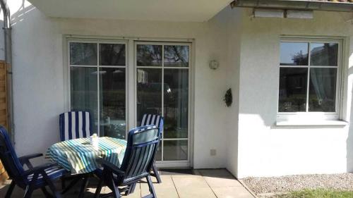 a table and chairs on a patio with a glass door at Ferienwohnung Sonneneck Poel in Timmendorf