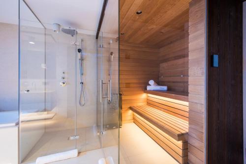 a bathroom with a walk in shower next to a tub at Nidus Luxury Apartments in Lech am Arlberg