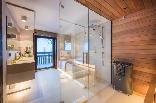 a bathroom with a glass shower and a sink at Nidus Luxury Apartments in Lech am Arlberg