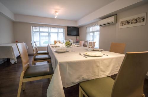 a dining room with a white table and chairs at Pension Oasis in Zamora