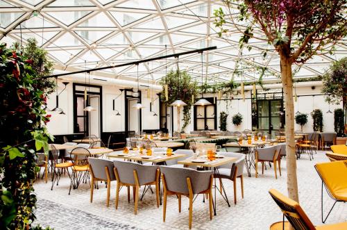 a restaurant with tables and chairs and a glass ceiling at Pestana Collection Plaza Mayor in Madrid