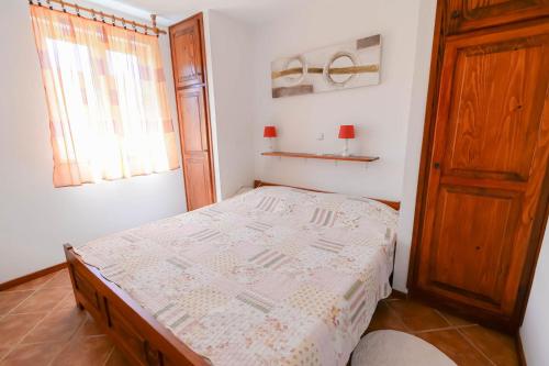 a small bedroom with a bed and a window at Cvita A2+1 in Veli Lošinj