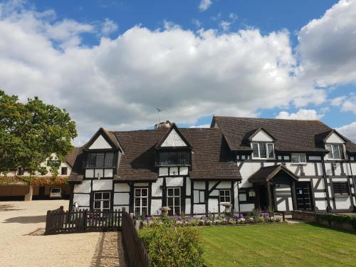 a large white and black house with a yard at The Thatch Inn in Gloucester