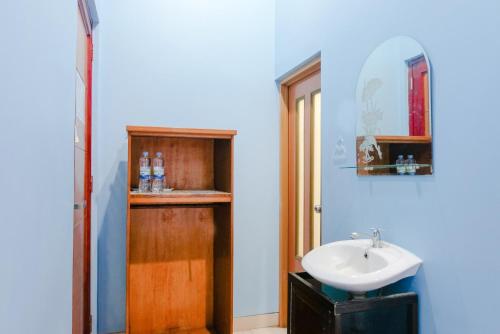a bathroom with a sink and a mirror at OYO 778 Guest House Amalia Malang in Malang
