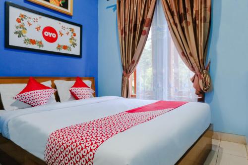 OYO 778 Guest House Amalia Malang tesisinde bir odada yatak veya yataklar
