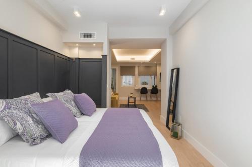 1 dormitorio con 1 cama grande con almohadas moradas en iloftmalaga Victoria 43, en Málaga