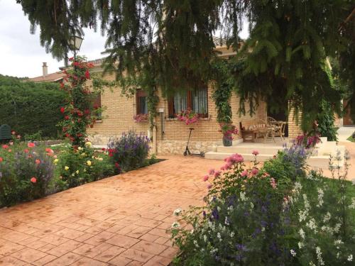 a brick driveway in front of a house with flowers at El Quinto Pino in Santibáñez del Val