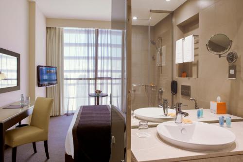 a large bathroom with two sinks and a shower at Centro Barsha - by Rotana in Dubai