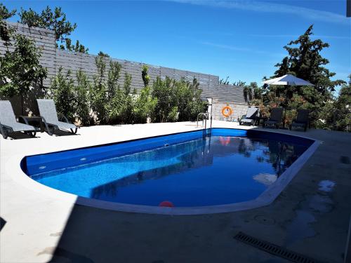 - une piscine d'eau bleue dans l'arrière-cour dans l'établissement Seaside Pool Villa Porto Rafti with Spectacular Sea View, à Pórto Ráfti