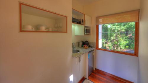 a small kitchen with a sink and a window at Montville Ocean View Cottages in Montville