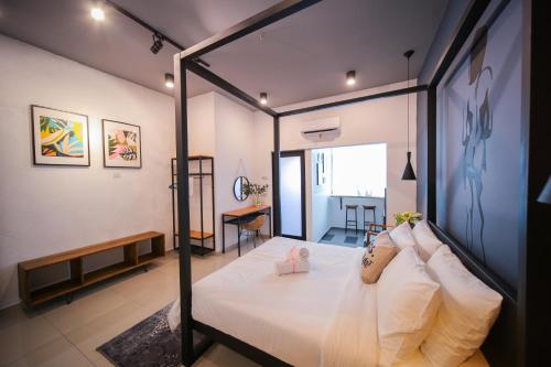峇六拜The Best Hotel in Bayan Lepas - THE LOV PENANG的一间卧室配有一张带白色床单的大床